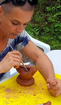 Stagiaire concentrée sur sa sculpture en argile